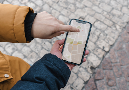 duas pessoas a apontar para o GPS no telemóvel