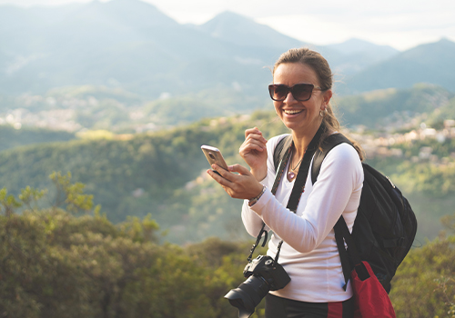 turista a utilizar telemóvel para ver roteiro da viagem em curso