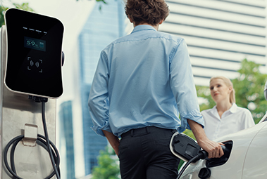 casal na cidade a carregar o carro el&eacute;trico