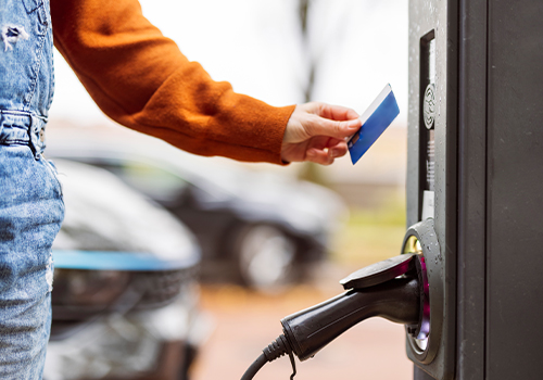Mulher a pagar com cartão de carregamento el&eacute;trico