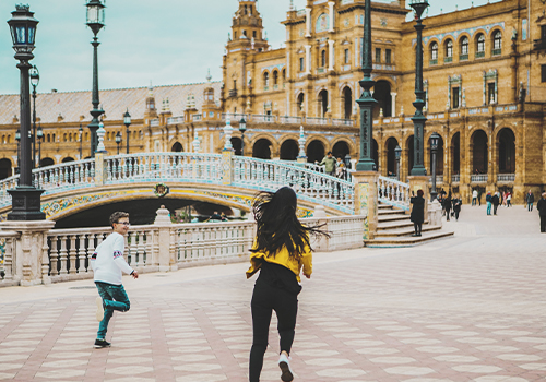 Crianças a correr numa praça em Sevilha.